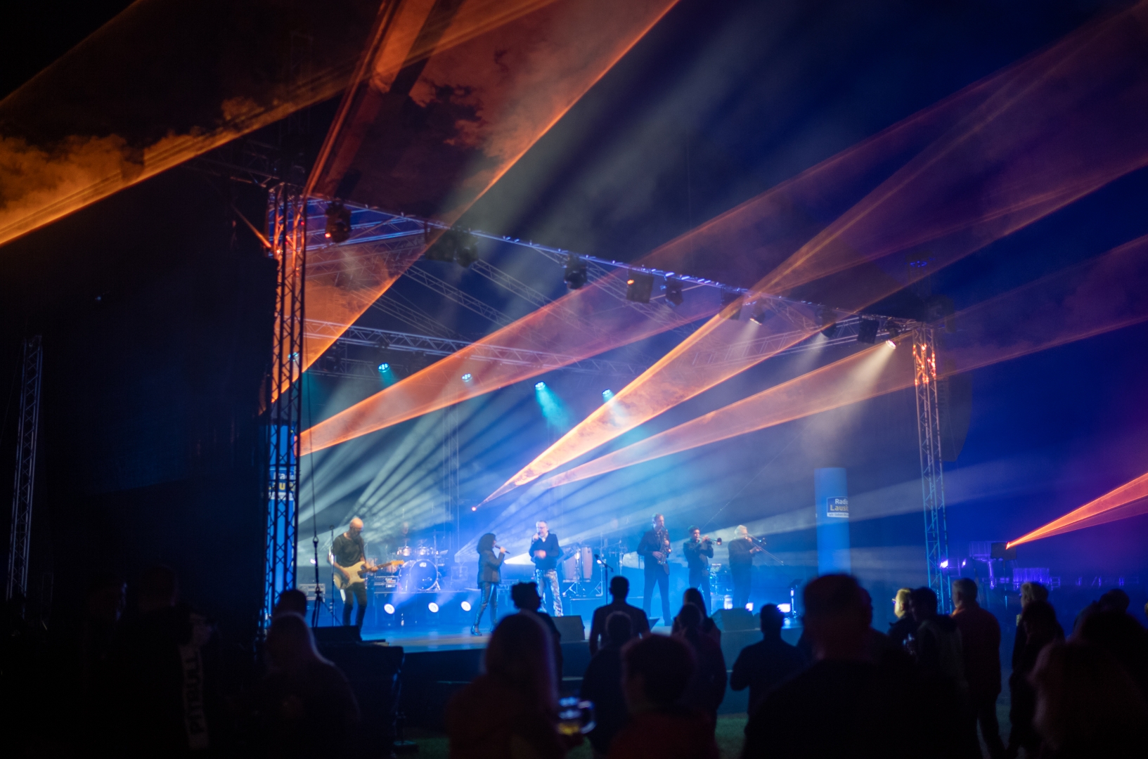 Konzertbühne bei Nacht mit einer eindrucksvollen Lasershow in Orange und Blau