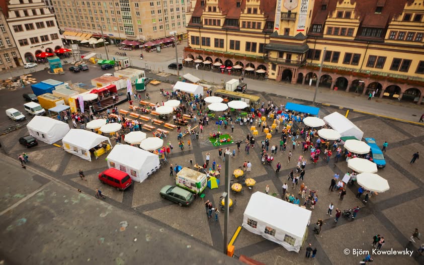 Luftaufnahme eines Marktplatzes beim Aufbau von Bühnen und Zelten für ein Stadtfest